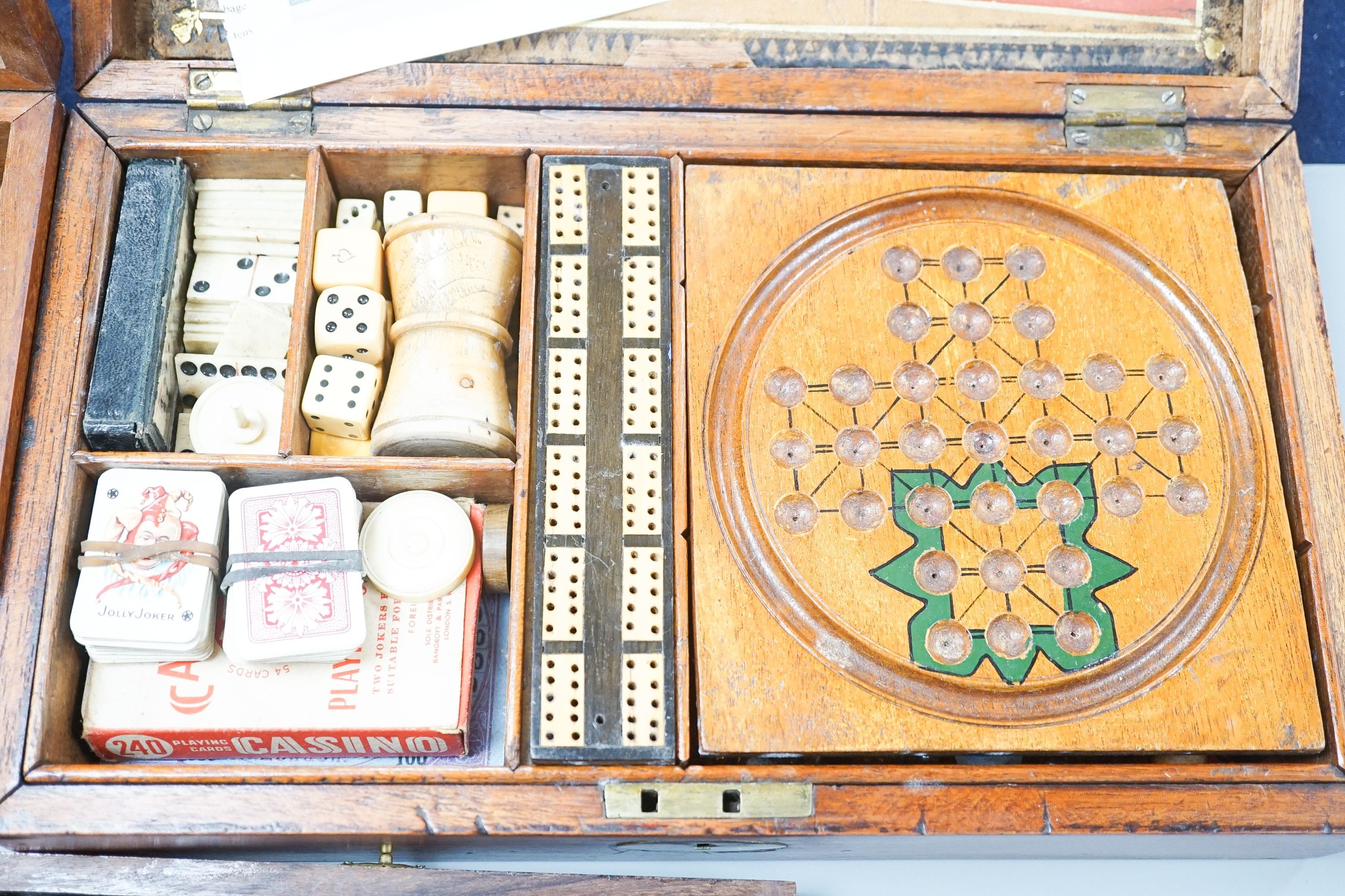 A Victorian brass inset mahogany games box, fitted with solitaire, cribbage, chessmen, draughts etc., 33cm, a turned and stained bone chess set, another games box containing chessmen and draughts